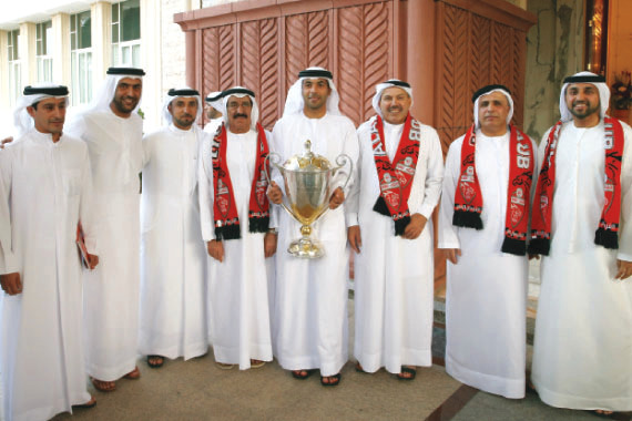 "كأس رئيس الدولة مع أحمد شاه وعلى يمينه محمد النابودة وسلطان السبوسي وعبدالله النابودة وسعيد جابر،وعلى يساره مصبح الفتان ومطر الطاير وخليفة سليمان"