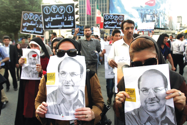 "مناصرتان للمرشح قاليباف تحملان صورته خلال مسيرة انتخابية في طهران \tرويترز"