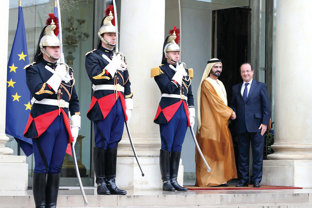"الرئيس الفرنسي مرحباً بمحمد بن راشد عند مدخل الإليزيه"