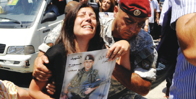 "لبنانية تبكي خلال جنازة أحد الجنود الذين قتلوا في اشتباكات صيدا\tرويترز"