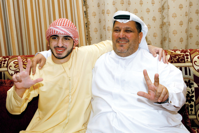 "سلطان ووالده يرفعان علامة النصر"