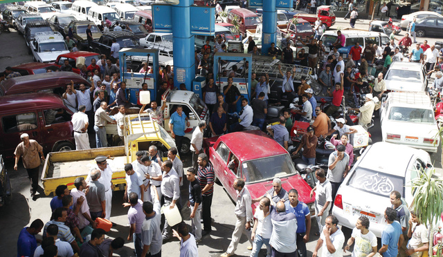 "مئات المصريين ينتظرون وسط الازدحام في طوابير طويلة للتعبئة في محطة بترول وسط أزمة وقود خانقة تعيشها البلاد في ظل حكم محمد مرسي \t رويترز"