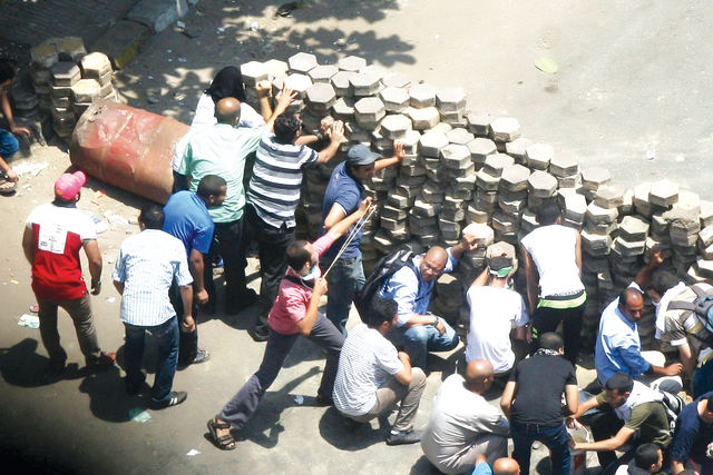 "اتباع الجماعة يقيمون ساتراً من الحجارة للتصدي لقوات الأمن في ميدان مصطفى محمود أ.ف.ب"