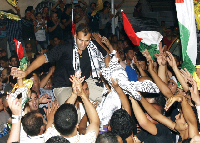 "أسير فلسطيني محرر يحيي أبناء بلدته عزموت قرب نابلس بعد الإفراج عن 26 أسيراً الأربعاء كدفعة أولى   \t\t  رويترز"