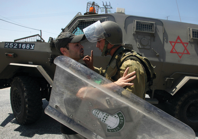 "متظاهر فلسطيني يواجه جندياً إسرائيلياً أثناء قمع تظاهرة ضد الاستيطان          \t       أ.ف.ب"