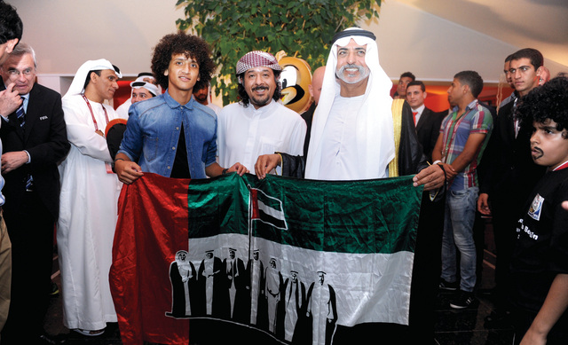 "نهيان بن مبارك وعمر عبدالرحمن يحملان علم الإمارات \tالبيان"