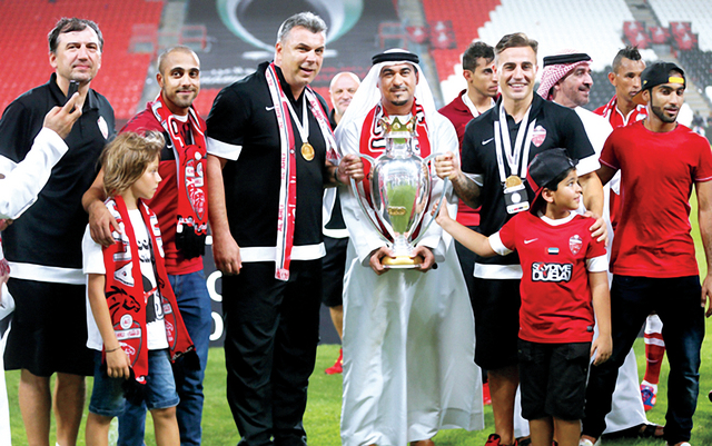 "عبد المجيد حسين يحمل الكأس مع أعضاء الجهاز الفني \t من المصدر"