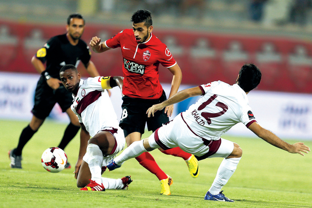 "لاعب الأهلي ماجد حسن يحاول المرور من مدافعي الوحدة\t تصوير - سالم خميس"