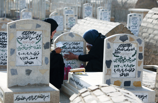 "عراقيتان تقضيان أول أيام العيد بزيارة قبر أفراد أسرتيهما في بغداد أ.ف.ب"