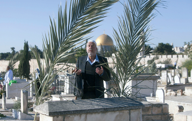 "فلسطيني يقرأ الفاتحة على روح أحد أقاربه في مقبرة تطل على المسجد الأقصى المبارك\t\t\t\t\t\t\t\t\t\t أ.ف.ب"