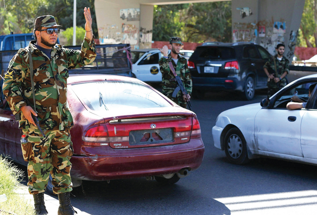 "رجال أمن ليبيون في نقطة تفتيش خلال تأمين العاصمة طرابلس الأحد الماضي الذي صادف الذكرى الثانية لمقتل العقيد معمر القذافي في سرت. أ.ف.ب"