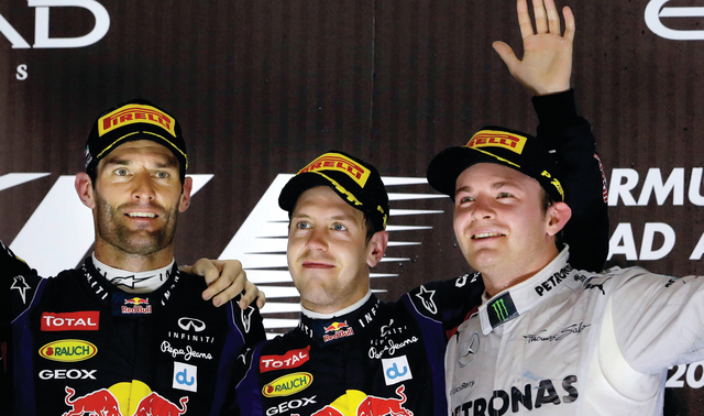 "الألماني سيباستيان صاحب المركز الأول يتوسط زميليه الأسترالي مارك ويبر والألماني نيكو روزبرغ على منصة التتويج.               أ ف ب"
