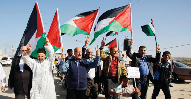 "فلسطينيون ومتضامنون أجانب في احتجاج عند معبر بيت حانون ضد حصار غزة \tرويترز"