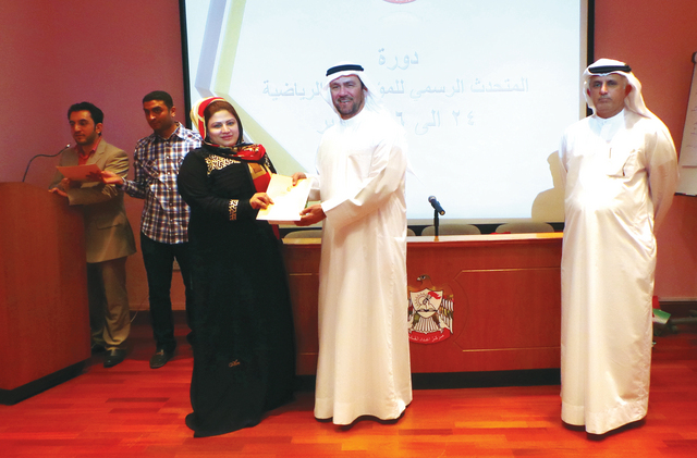 "بن هزيم وجاني خلال تكريم إحدى المشاركات في الدورة   \t   البيان"