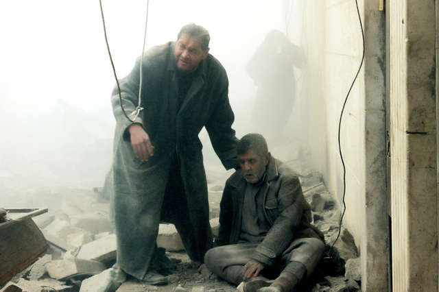 "سوري يحاول مساعدة أحد المصابين بين الأنقاض في غارة لطيران النظام على حي المعادي في حلب أ.ف.ب"