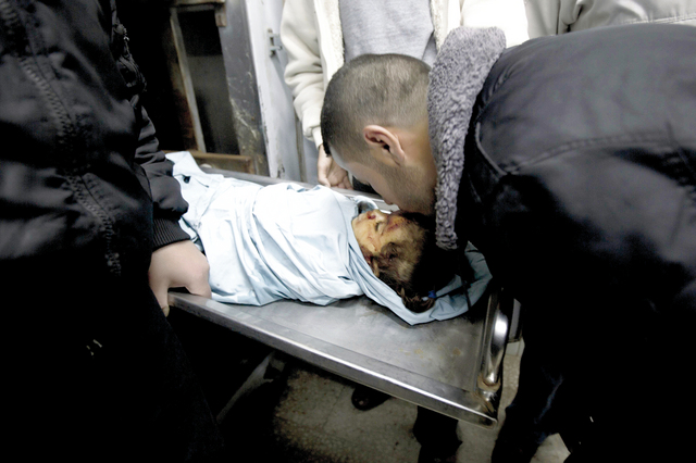 "أحد أقارب الشهيدة الفلسطينية الطفلة حلا أبوسبيخة يقبل جبينها بعدما استهدفتها غارة إسرائيلية على غزة أ.ف.ب"