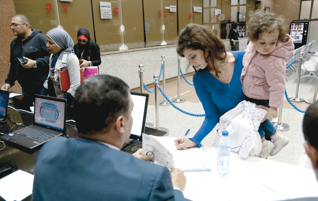"..ومصرية تصطحب طفلتها خلال عملية التصويت في مقر القنصلية المصرية بدبي \t تصوير ـ محمود الخطيب"