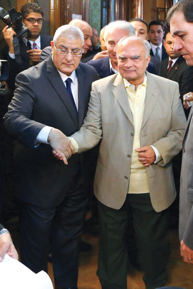 "عدلي منصور يساعد مسناً للإدلاء بصوته  \t\t\t\t\t\t\t   أ.ف.ب"