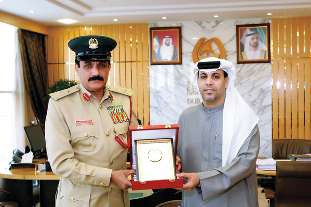 "اللواء خميس مطر المزينة القائد العام لشرطة دبي يهدي ظاعن شاهين المدير التنفيذي لقطاع النشر في مؤسسة دبي للإعلام رئيس تحرير «البيان» درع شرطة دبي التذكارية الذي يرمز إلى الخير والسلام"