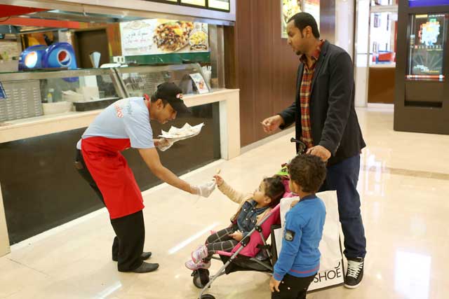 "المتسوقون يتذوقون أشهى أنواع الأطعمة العالمية"