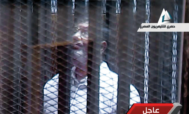 "صورة تلفزيونية تظهر مرسي يقف داخل قفص معدني في قاعة المحكمة \tأ.ب"