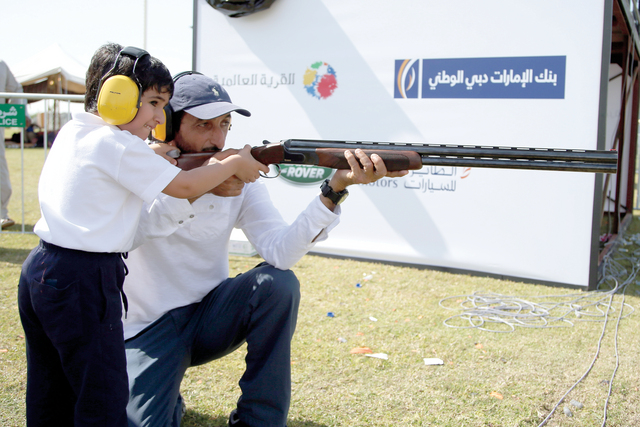 "أحمد بن حشر يعلّم ابنه محمد الرماية خلال حضوره فعاليات البطولة أمس تصوير -خالد نوفل"