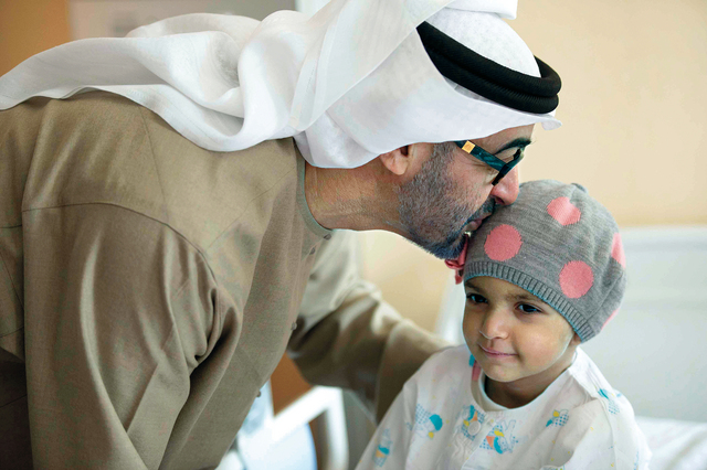 "سموه يقبل أحد الأطفال المرضى"