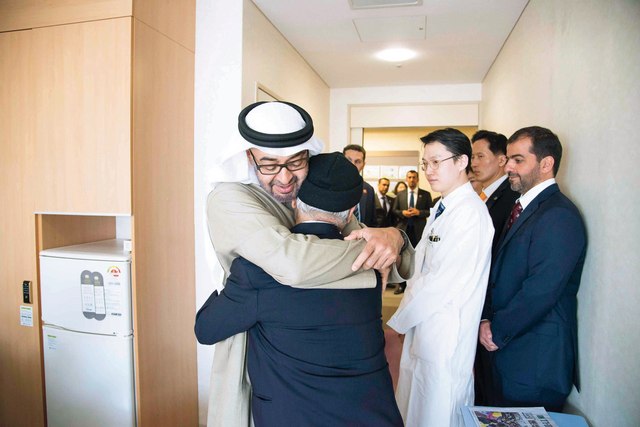 "سموه يحتضن أحد المرضى"