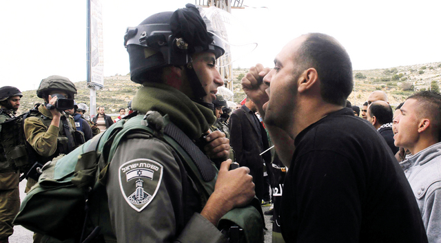 "متظاهر فلسطيني قرب بيت لحم في مواجهة مع جندي إسرائيلي خلال تظاهرة في ذكرى يوم الأرض  \t     رويترز"