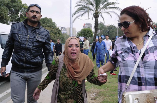 "مصري يساعد امرأة مفجوعة في مغادرة موقع التفجير\tأ.ب"