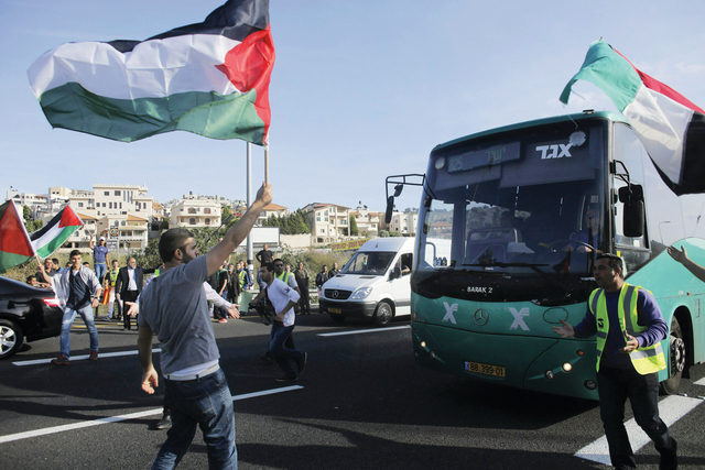 "فلسطينيون من سكان المناطق المحتلة عام 48 يمنعون حافلة إسرائيلية من المرور خلال تظاهرة احتجاجية ضد الهجوم على مسجد في بلدة أم الفحم. رويترز"