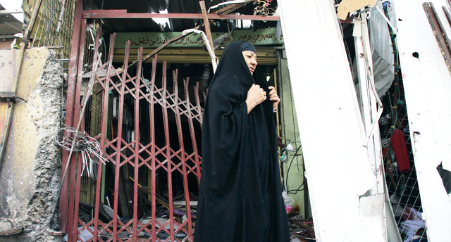 "امرأة عراقية تقف على آثار تفجيرات في مدينة الصدر رويترز"