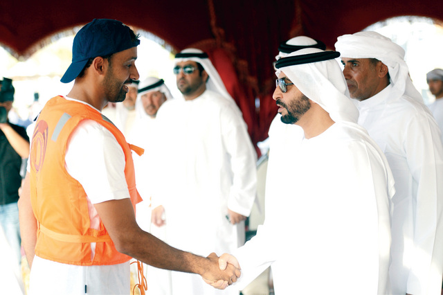 ".. وسموه يرحب بأحد المشاركين في الحدث. وام"