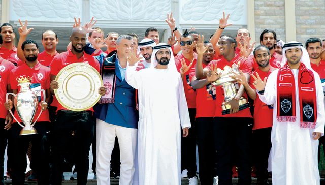 "محمد بن راشد وحمدان بن محمد يتوسطان نجوم الأهلي أبطال ثلاثية الموسم \t تصوير: خليفة اليوسف"