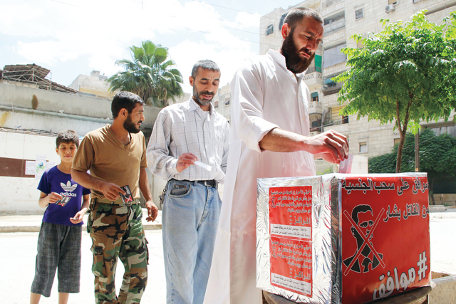 "معارضون للنظام في حلب يدلون بأصوات في صندوق أحمر في انتخابات تسخر من انتخابات نظام الأسد أ.ف.ب"