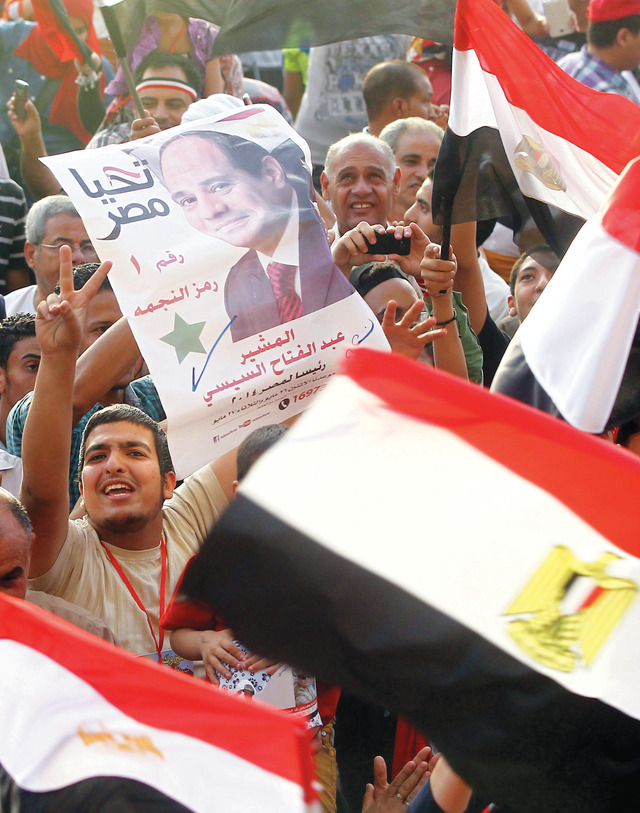 "مصريون يحملون صور السيسي وأعلام البلاد في ميدان التحرير \t إي بي إيه"