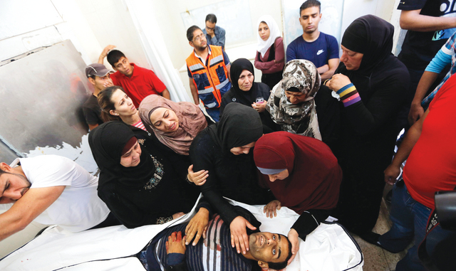 "أقارب أحد الشهيدين اللذين سقطا أمس على يد قوات الاحتلال يبكونه قبل تشييعه في رام الله \t\t رويترز"