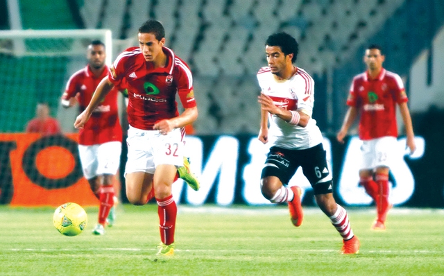 "رمضان صبحي لاعب الأهلي ينطلق بالكرة ومطاردة من عمر جابر لاعب الزمالك البيان"