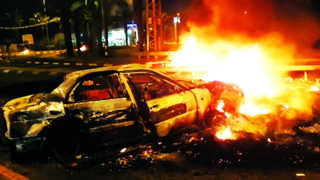 "بقايا سيارة أحرقت من قبل المحتجين الفلسطينيين في قرية قلنسوة في مناطق الـ48 أ.ب"