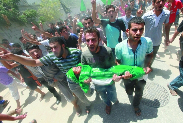 "فلسطينيون يشيعون الطفل محمد مناصرة (3 سنوات) الذي استشهد مع أخيه ووالديه بقصف منزلهم في مخيم المغازي إي بي إيه"