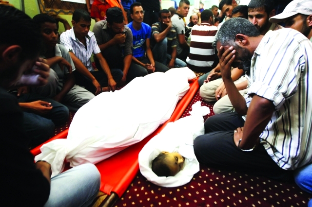 "فلسطينيون يبكون رضيعاًُ استشهد مع فلسطيني آخر في العدوان أ.ف.ب"