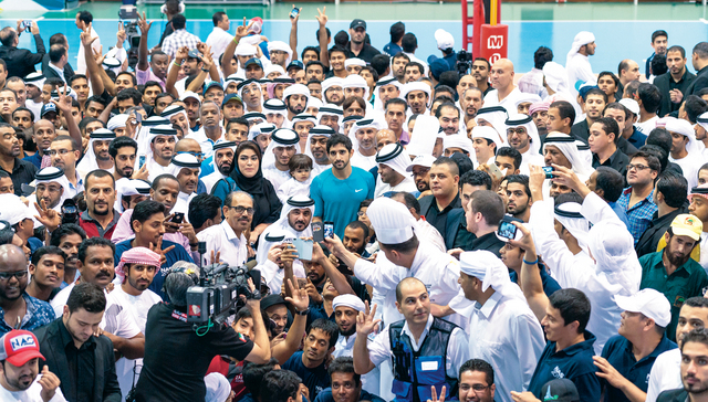 "حمدان بن محمد بن راشد آل مكتوم يتوسط العاملين في اللجان وفرق الدعم للدورة\t \tتصوير - علي عيسى"