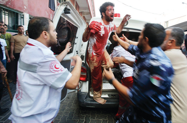 "شاب مضرّج بدماء والده الذي قضى نحبه في الطريق إلى المستشفى رويترز"