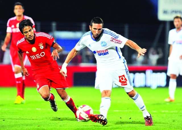 "Marseille's Morgan Amalfitano (C) kicks the ball during the French Ligue 1 friendly football match between Marseille (OM) and Benfica Lisbonne, on July 23, 2014 at the Montpied Stadium in Clermont-Ferrand. AFP PHOTO / THIERRY ZOCCOLAN"