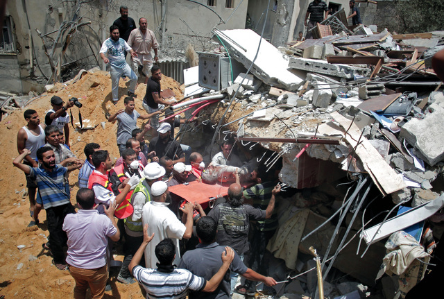 "فلسطينيون ينتشلون شهيداً من بين أنقاض منزل قصفته طائرات الاحتلال فوق رؤوس أصحابه في غزة أ.ب"