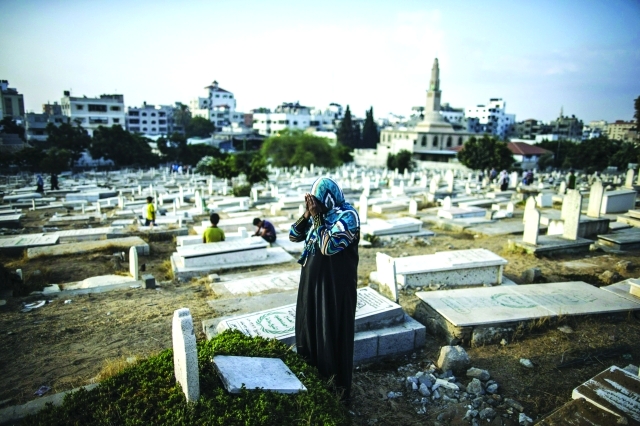 "فلسطينية تبكي شهداءها في زيارة لمقبرة الشيخ رضوان بمناسبة العيد الذي تعيشه غزة بالدماء والدموع أ.ف.ب"