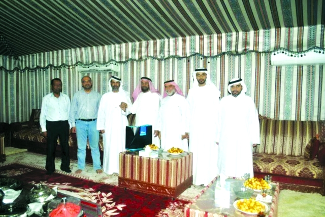 "وفد من الصحافيين مع أحد كبار السن أثناء تقديم الهدايا"
