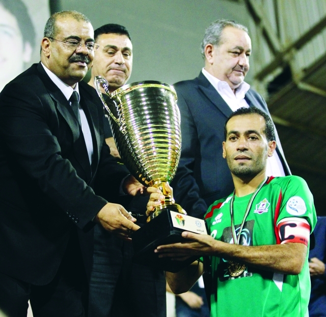 "كابتن الوحدات عامر ذيب يتسلم كأس البطولة من صلاح الدين صبرة"