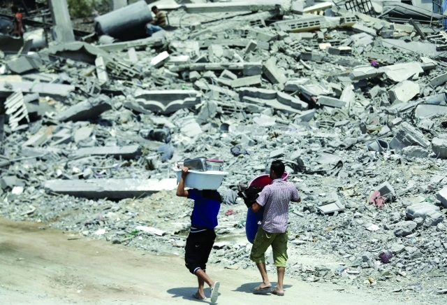 "فلسطينيان يسيران وسط أنقاض منازل دمرها الاحتلال في بيت حانون \t\t\t\t\t\t\t\t\t\t\t\t\t أ.ب"