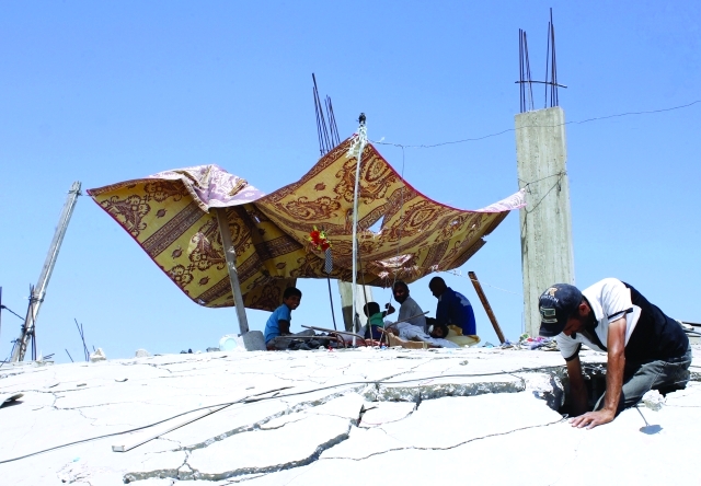 "فلسطيني يبحث في حفرة بمنزله الذي دمرته غارة إسرائيلية في عبسان أ.ف.ب"